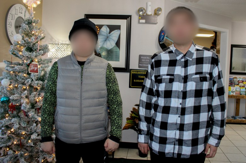 Two Chinese men with blurred faces standing together in a hotel lobby.