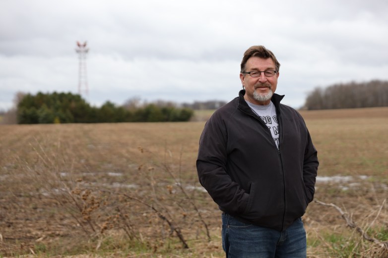 Tim Schmitz stands with a light brown farm field behind him.