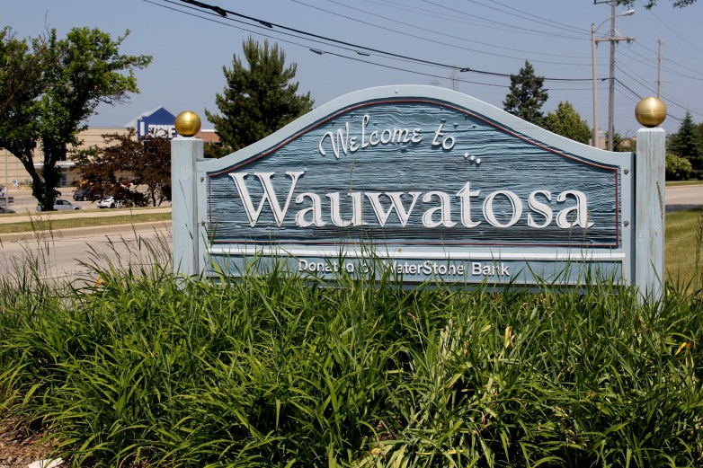 A sign next to a street says 