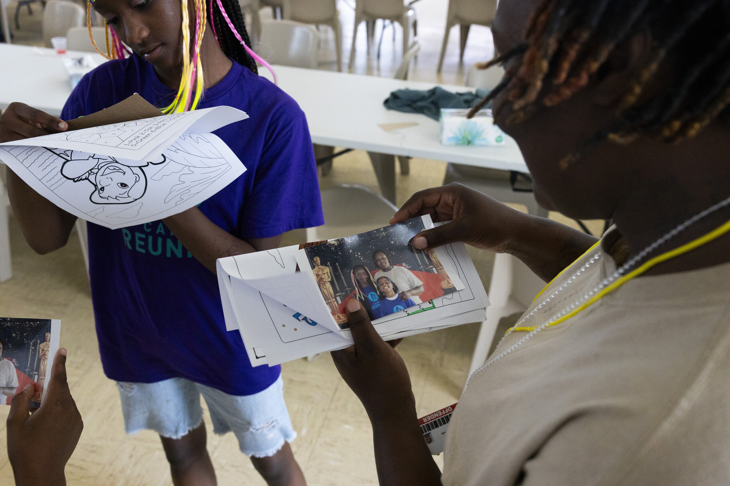 Woman and girl look at photos.