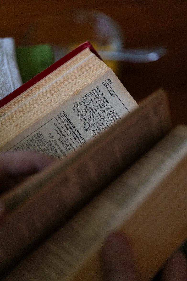 An open book shows a page with small printed text including 