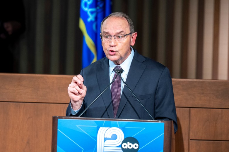 A man in a suit at a podium speaks